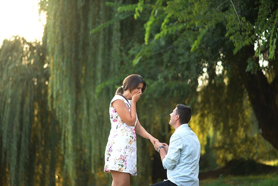 man kneeling and proposing to girl